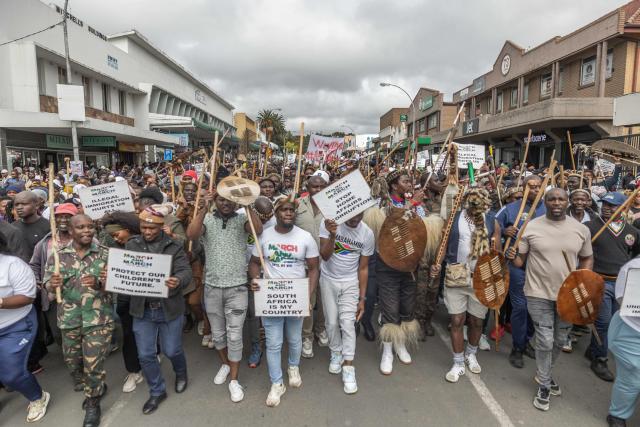 Protesters carry placards during a protest march against undocumented migrants in the town of Estcourt on April 24, 2026. South Africa's acting police minister has condemned xenophobic incidents, saying attacks on foreign nationals were "unlawful" and violated the country's constitutional values of dignity and equality. (Photo by RAJESH JANTILAL / AFP)
