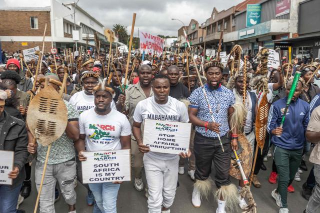 Protesters carry placards during a protest march against undocumented migrants in the town of Estcourt on April 24, 2026. South Africa's acting police minister has condemned xenophobic incidents, saying attacks on foreign nationals were "unlawful" and violated the country's constitutional values of dignity and equality. (Photo by RAJESH JANTILAL / AFP)