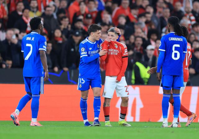 (FILES) SL Benfica's Argentine forward #25 Gianluca Prestianni hides his mouth while arguing with Real Madrid's Brazilian forward #07 Vinicius Junior who complained about alleged racists insults during the UEFA Champions League knockout round play-off first leg football match between SL Benfica and Real Madrid CF at Estadio da Luz in Lisbon on February 17, 2026. UEFA banned Benfica winger Gianluca Prestianni for six matches on April 24, 2026 after a controversial incident in the Champions League clash against Real Madrid in February. The European football governing body said they had taken the decision to ban the Argentine "for discriminatory (i.e. homophobic) conduct", with three of those matches suspended for a two-year probationary period. (Photo by PATRICIA DE MELO MOREIRA / AFP)
