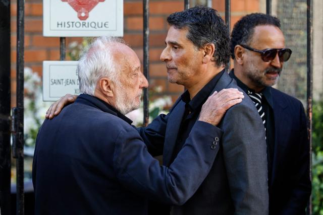 French actor Francois Berleand (L) greets actor Pascal Elbe upon arrival for the funeral ceremony of French actress Nadia Fares at the Saint-Jean de Montmartre church in Paris on April 24, 2026. Nadia Fares died on April 17, 2026, aged 57, after being found unconscious in a swimming pool in Paris and several days in a coma. (Photo by SIMON WOHLFAHRT / AFP)