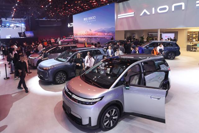 Visitors look at cars on the Aion stand on the opening day of the Beijing Auto Show in Beijing on April 24, 2026. (Photo by CN-STR / AFP) / China OUT