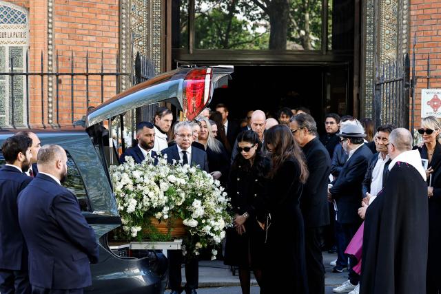 Nadia Fares' daughters Cylia Chasman (C) and Shana Chasman (C-R) mourn in front of the coffin of their mother after the funeral ceremony at the Saint-Jean de Montmartre church in Paris on April 24, 2026. Nadia Fares died on April 17, 2026, aged 57, after being found unconscious in a swimming pool in Paris and several days in a coma. (Photo by SIMON WOHLFAHRT / AFP)