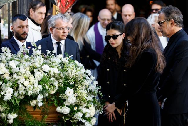 Nadia Fares' daughters Cylia Chasman (C) and Shana Chasman (C-R) mourn in front of the coffin of their mother after the funeral ceremony at the Saint-Jean de Montmartre church in Paris on April 24, 2026. Nadia Fares died on April 17, 2026, aged 57, after being found unconscious in a swimming pool in Paris and several days in a coma. (Photo by SIMON WOHLFAHRT / AFP)