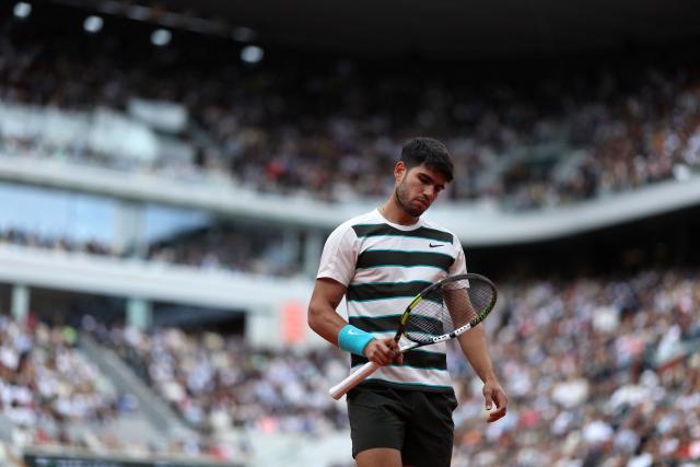 (FILES) Spain's Carlos Alcaraz looks at his racket as he plays against Italy's Jannik Sinner during their men's singles final match on day 15 of the French Open tennis tournament on Court Philippe-Chatrier at the Roland-Garros Complex in Paris on June 8, 2025. Two-time reigning French Open champion Carlos Alcaraz said on April 24, 2026 he will not play at this year's tournament as he recovers from a wrist injury."We have decided that the most prudent thing to do is to be cautious and not participate in Rome or Roland Garros," Alcaraz said on social media. (Photo by Alain JOCARD / AFP)