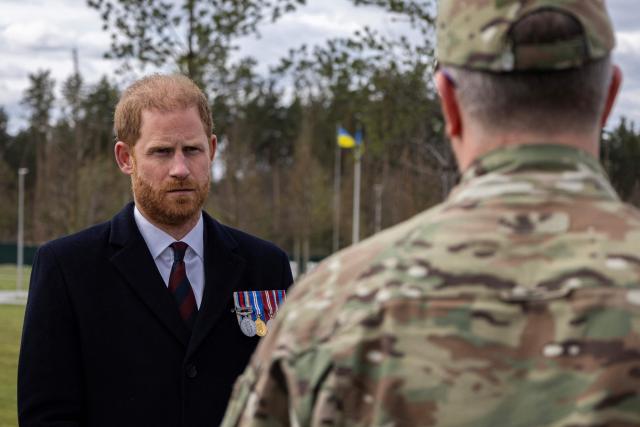 Britain's Prince Harry, Duke of Sussex (L), listens to a member of Ukrainian army as he visits The National War Memorial Cemetery to pay tribute to the graves of unknown Ukrainian servicemen in Kyiv on April 24, 2026, amid Russian invasion in Ukraine. (Photo by Serhii Okunev / AFP)