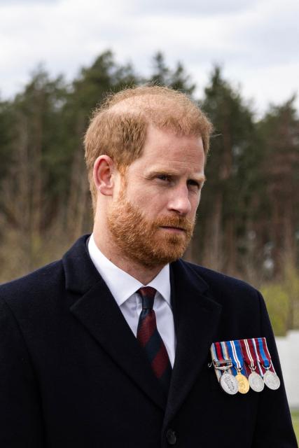 Britain's Prince Harry, Duke of Sussex, listens to a member of Ukrainian army as he visits The National War Memorial Cemetery to pay tribute to the graves of unknown Ukrainian servicemen in Kyiv on April 24, 2026, amid Russian invasion in Ukraine. (Photo by Serhii Okunev / AFP)