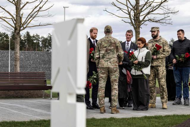 Britain's Prince Harry, Duke of Sussex (L), listens to a member of Ukrainian army as he visits The National War Memorial Cemetery to pay tribute to the graves of unknown Ukrainian servicemen in Kyiv on April 24, 2026, amid Russian invasion in Ukraine. (Photo by Serhii Okunev / AFP)