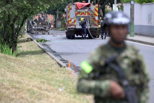 Colombian firefighters inspect the area where a bus bomb exploded near a military base in Cali, Valle del Cauca department, Colombia on April 24, 2026. One person was injured in an attack on a military base in southwest Colombia on April 24, 2026, according to the local health authority, one month ahead of the presidential election. (Photo by Joaquin SARMIENTO / AFP)