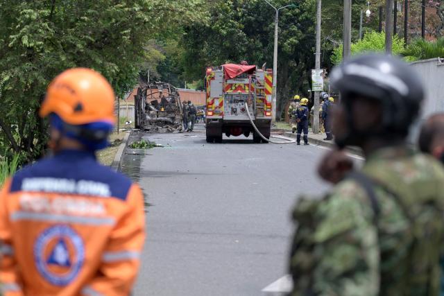 Colombian firefighters inspect a bus bomb after an explosion near a military base in Cali, Valle del Cauca department, Colombia on April 24, 2026. One person was injured in an attack on a military base in southwest Colombia on April 24, 2026, according to the local health authority, one month ahead of the presidential election. (Photo by Joaquin SARMIENTO / AFP)