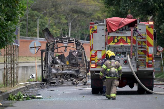 Colombian firefighters inspect a bus bomb after an explosion near a military base in Cali, Valle del Cauca department, Colombia on April 24, 2026. One person was injured in an attack on a military base in southwest Colombia on April 24, 2026, according to the local health authority, one month ahead of the presidential election. (Photo by Joaquin SARMIENTO / AFP)