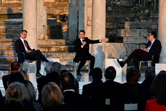 Greece's Prime Minister Kyriakos Mitsotakis, France's President Emmanuel Macron, and Kathimerini Executive Editor Alexis Papachelas  speak on stage during an event at the Roman Agora in Athens, on April 24, 2026. Alexis Papachelas. Emmanuel Macron visits Athens to strengthen Franco-Greek cooperation on defence and security. (Photo by Aris MESSINIS / AFP)