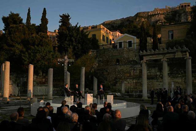 Greece's Prime Minister Kyriakos Mitsotakis, France's President Emmanuel Macron, and Kathimerini Executive Editor Alexis Papachelas  speak on stage during an event at the Roman Agora in Athens, on April 24, 2026. Alexis Papachelas. Emmanuel Macron visits Athens to strengthen Franco-Greek cooperation on defence and security. (Photo by Aris MESSINIS / AFP)