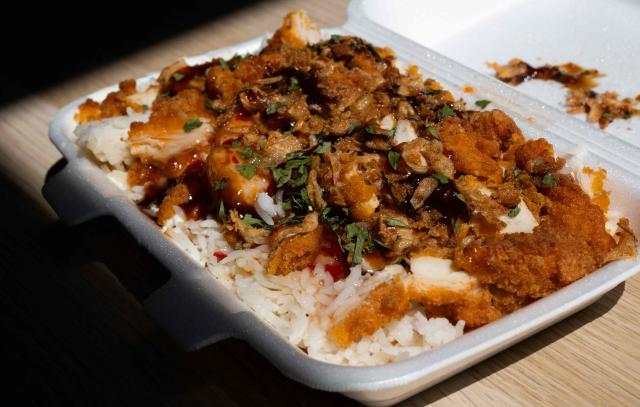 This photograph shows a take away "Crousty" dish in an appartment in Saint-Mandé, east of Paris, on April 24, 2026. An affordable, high-calorie dish made with rice and fried chicken and popularized on social media, the "crousty" has become a commercial phenomenon and a flagship fast-food item that eclipses burgers, tacos, and kebabs. (Photo by Martin LELIEVRE / AFP)