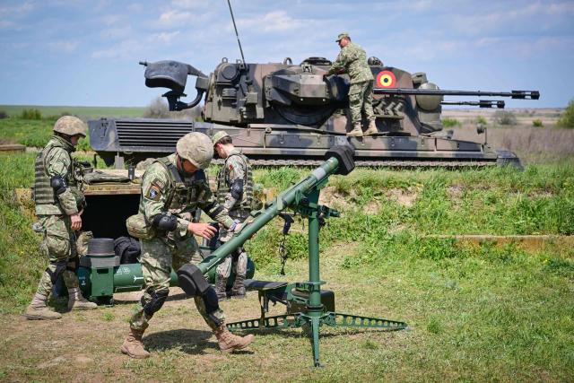Romanian army personnel install a KP-SAM Chiron a Korean Portable-Surface to Air Missile during exercise EASTERN PHOENIX 26, a training activity designed to test counter-unmanned aircraft systems (C-UAS) procedures, at Capu Midia firing range, April 24, 2026. The exercise, which includes NATO’s first "Crucible Series" event, aims to strengthen national defense and NATO’s Eastern Flank by integrating kinetic and non-kinetic responses to airspace incursions with special interest in the testing of anti-drones measures. Participants included aproximately 250 Romanian military personnel and 250 industry representatives from 21 NATO allied nations. (Photo by Daniel MIHAILESCU / AFP)