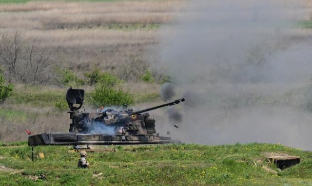 Romanian army's self-propelled anti-aircraft gun "Ghepard" fires during exercise EASTERN PHOENIX 26, a training activity designed to test counter-unmanned aircraft systems (C-UAS) procedures, at Capu Midia firing range, April 24, 2026. The exercise, which includes NATO’s first "Crucible Series" event, aims to strengthen national defense and NATO’s Eastern Flank by integrating kinetic and non-kinetic responses to airspace incursions with special interest in the  testing of anti-drones measures. Participants included aproximately 250 Romanian military personnel and 250 industry representatives from 21 NATO allied nations . (Photo by Daniel MIHAILESCU / AFP)