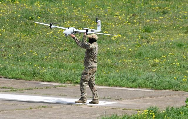 A romanian army serviceman catches a "Vector" surveillance drone while landing during exercise EASTERN PHOENIX 26, a training activity designed to test counter-unmanned aircraft systems (C-UAS) procedures, at Capu Midia firing range, April 24, 2026. The exercise, which includes NATO’s first "Crucible Series" event, aims to strengthen national defense and NATO’s Eastern Flank by integrating kinetic and non-kinetic responses to airspace incursions with special interest in the testing of anti-drones measures. Participants included aproximately 250 Romanian military personnel and 250 industry representatives from 21 NATO allied nations. (Photo by Daniel MIHAILESCU / AFP)