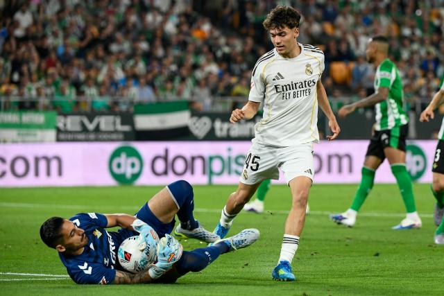 Real Madrid's Spanish midfielder #45 Thiago Pitarch (R) tries but fails to score past Real Betis' Spanish goalkeeper #01 Alvaro Valles during the Spanish league football match between Real Betis and Real Madrid CF at the La Cartuja stadium in Seville on April 24 , 2026. (Photo by CRISTINA QUICLER / AFP)