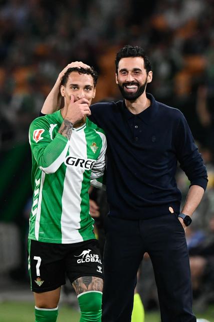 Real Betis' Brazilian forward #07 Antony coincides with Real Madrid's Spanish coach Alvaro Arbeloa during the Spanish league football match between Real Betis and Real Madrid CF at the La Cartuja stadium in Seville on April 24 , 2026. (Photo by CRISTINA QUICLER / AFP)