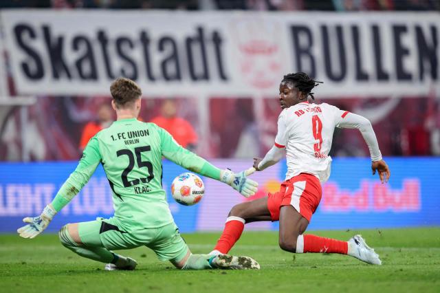 Leipzig's Belgian forward #09 Johan Bakayoko (R) attempts to score past Union Berlin's German goalkeeper #25 Carl Klaus during the German first division Bundesliga football match between RB Leipzig and Union Berlin in Leipzig, eastern Germany, on April 24, 2026. (Photo by Ronny HARTMANN / AFP) / DFL REGULATIONS PROHIBIT ANY USE OF PHOTOGRAPHS AS IMAGE SEQUENCES AND/OR QUASI-VIDEO
