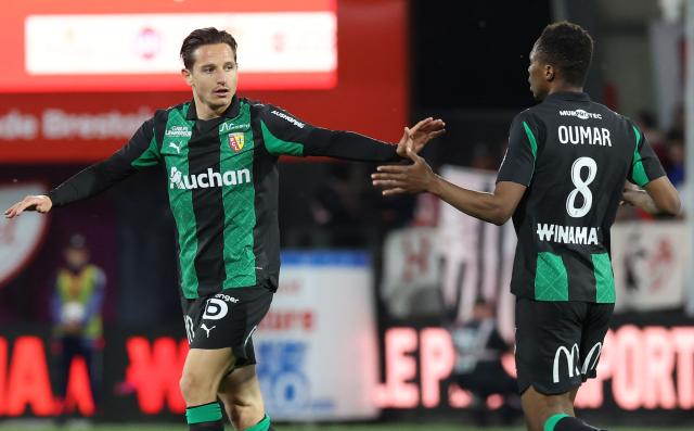 Lens' French forward #10 Florian Thauvin (L) is congratulated by Lens' Malian midfielder #08 Mamadou Sangare after scoring his team's first goal during the French L1 football match between Stade Brestois 29 (Brest) and RC Lens at the Stade Francis-Le-Ble in Brest, western France, on April 24, 2026. (Photo by Fred TANNEAU / AFP)