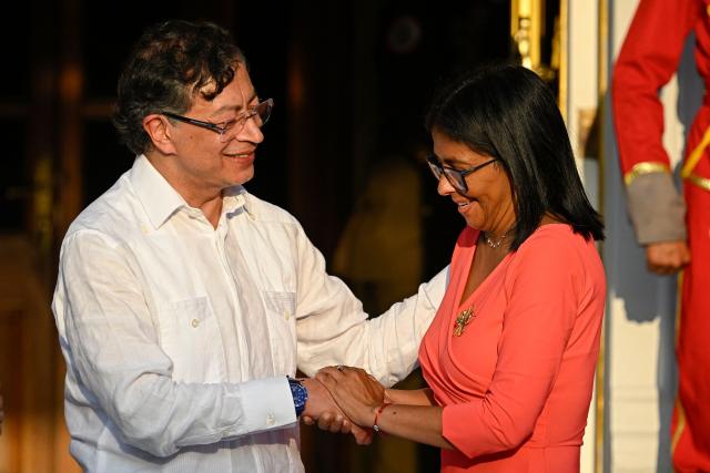 Venezuela's interim President Delcy Rodriguez (R) and Colombian President Gustavo Petro shake hands after delivering statements following a bilateral meeting at the Miraflores presidential palace in Caracas on April 24, 2026. Colombia's President Gustavo Petro arrived in Venezuela on April 24 for a bilateral meeting with interim President Delcy Rodriguez, focusing on border security and energy cooperation. (Photo by Federico PARRA / AFP)