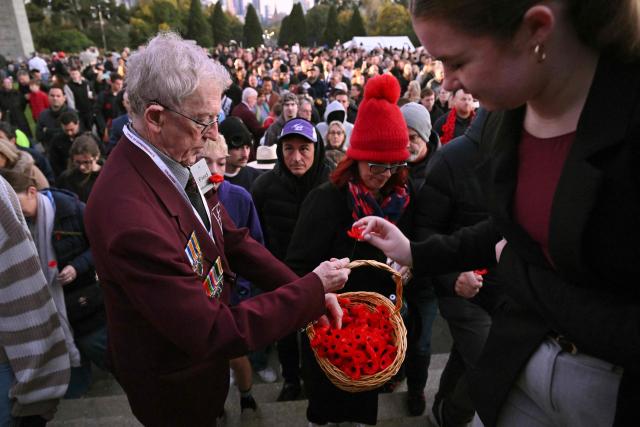 People take a poppy to lay in the Shrine after the Anzac Day dawn service at the Shrine of Remembrance to remember soldiers who have died in war, in Melbourne on April 25, 2026. (Photo by William WEST / AFP)