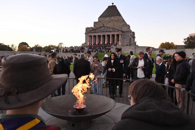 People look at the Eternal Flame after the Anzac Day dawn service at the Shrine of Remembrance to remember soldiers who have died in war, in Melbourne on April 25, 2026. (Photo by William WEST / AFP)