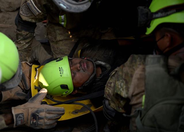 Salvadoran soldiers take part in a post-earthquake rescue simulation during the final phase of a 36 hour emergency exercise, held as part of the CENTAM Guardian 2026 military drills, at the Engineers Corps (CIFA) facilities in San Juan Opico, El Salvador on April 24, 2026. (Photo by Marvin RECINOS / AFP)