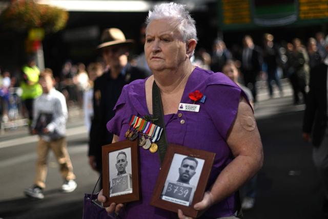 A participant carries photos of soldiers during the annual ANZAC (Australian and New Zealand Army Corps) Day parade in Sydney on April 25, 2026. Dawn services were held across the two countries on the anniversary of the ill-fated 1915 campaign of the Australian and New Zealand Army Corps that left 11,500 of them dead in what is now Turkey during World War I. (Photo by Saeed KHAN / AFP)