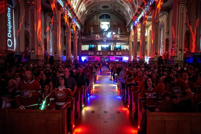 Montreal Canadiens fans watch the live broadcast of the Stanley Cup playoff game against Tampa Bay Lightning inside the Cathedrale Saint-Jean-l’Evangeliste, in Saint-Jean-sur-Richelieu, Quebec, on April 24, 2026. The cathedral, about 25 miles (40 kms) southeast of Montreal, is being transformed into a hockey "high mass" during the National Hockey League (NHL) playoffs. (Photo by ANDREJ IVANOV / AFP)