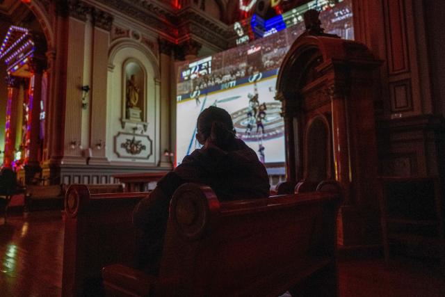 Montreal Canadiens fans watch the live broadcast of the Stanley Cup playoff game against Tampa Bay Lightning inside the Cathedrale Saint-Jean-l’Evangeliste, in Saint-Jean-sur-Richelieu, Quebec, on April 24, 2026. The cathedral, about 25 miles (40 kms) southeast of Montreal, is being transformed into a hockey "high mass" during the National Hockey League (NHL) playoffs. (Photo by ANDREJ IVANOV / AFP)