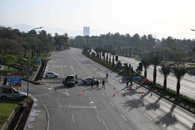Police officers stand guard at a closed street leading to the Serena Hotel, the venue for expected US-Iran talks, in Islamabad’s Red Zone on April 25, 2026. Iran's foreign minister arrived in Islamabad on April 24 and US envoys headed to the Pakistani capital in a bid to kickstart a new round of peace negotiations amid a fragile ceasefire. (Photo by Aamir QURESHI / AFP)