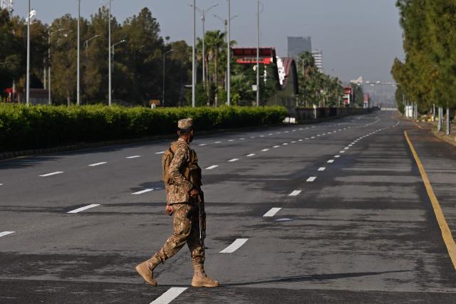 An army soldier walks a deserted street blocked at the Red Zone area in Islamabad on April 25, 2026. Iran's foreign minister arrived in Islamabad on April 24 and US envoys headed to the Pakistani capital in a bid to kickstart a new round of peace negotiations amid a fragile ceasefire. (Photo by Aamir QURESHI / AFP)