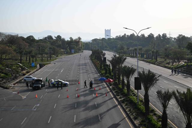 Police officers stand guard at a closed street leading to the Serena Hotel, the venue for expected US-Iran talks, in Islamabad’s Red Zone on April 25, 2026. Iran's foreign minister arrived in Islamabad on April 24 and US envoys headed to the Pakistani capital in a bid to kickstart a new round of peace negotiations amid a fragile ceasefire. (Photo by Aamir QURESHI / AFP)