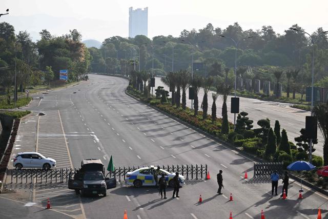 Police officers stand guard at a closed street leading to the Serena Hotel, the venue for expected US-Iran talks, in Islamabad’s Red Zone on April 25, 2026. Iran's foreign minister arrived in Islamabad on April 24 and US envoys headed to the Pakistani capital in a bid to kickstart a new round of peace negotiations amid a fragile ceasefire. (Photo by Aamir QURESHI / AFP)