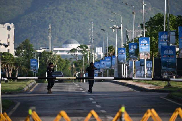Police officers walk near the Serena Hotel, the venue for expected US-Iran talks, in Islamabad’s Red Zone on April 25, 2026. Iran's foreign minister arrived in Islamabad on April 24 and US envoys headed to the Pakistani capital in a bid to kickstart a new round of peace negotiations amid a fragile ceasefire. (Photo by Aamir QURESHI / AFP)