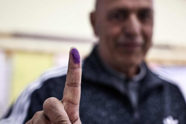 A Palestinian man shows his marked finger after casting his ballot at a polling station during municipal elections in the Israeli-occupied West Bank city of Al-Bireh on April 25, 2026. Palestinians in the West Bank and a central area of Gaza began voting on April 25 in municipal elections in a first vote since the Gaza war, marked by a narrow political field and widespread disillusionment. (Photo by Zain JAAFAR / AFP)