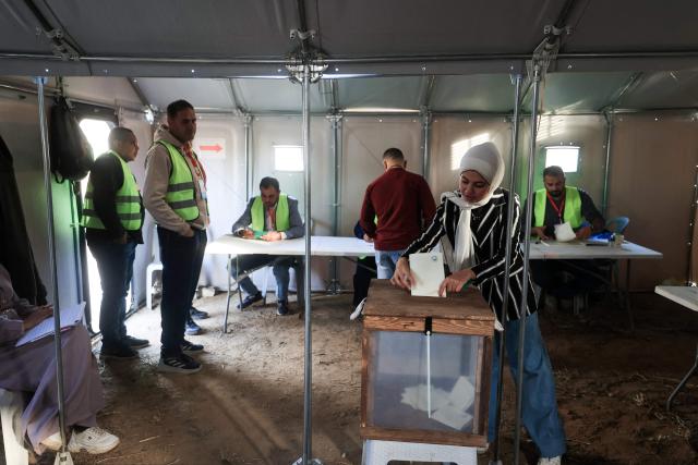 TOPSHOT - A Palestinian woman casts his vote during municipal elections in Deir el-Balah, Gaza Strip, on April 25, 2026. Palestinians in the West Bank and a central area of Gaza began voting on April 25 in municipal elections in a first vote since the Gaza war, marked by a narrow political field and widespread disillusionment. (Photo by Eyad Baba / AFP)