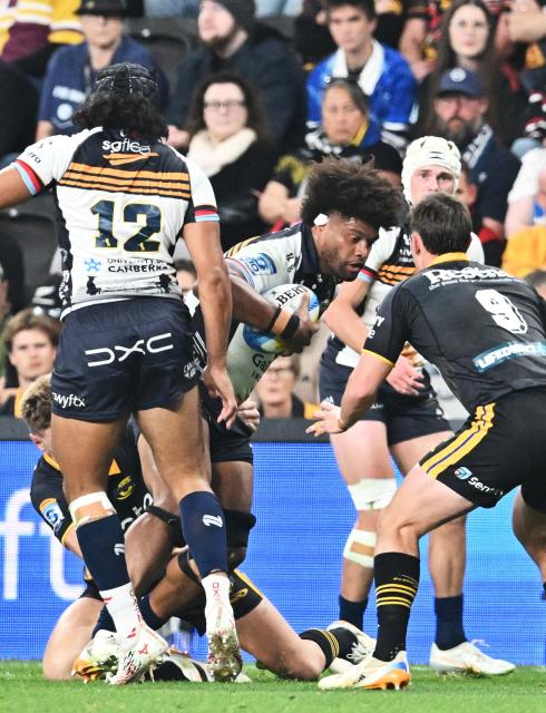 Brumbies' Rob Valetini (C) is tackled by Hurricanes' defence during round 11 Super Rugby Pacific match between the Hurricanes and Brumbies at One New Zealand Stadium in Christchurch on April 25, 2026. (Photo by Sanka VIDANAGAMA / AFP)
