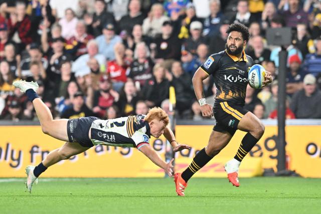 Hurricanes' Fehi Fineanganofo (R) charges forward to score a try during the Super Rugby Pacific match between the Hurricanes and Brumbies at One New Zealand Stadium in Christchurch on April 25, 2026. (Photo by Sanka Vidanagama / AFP)