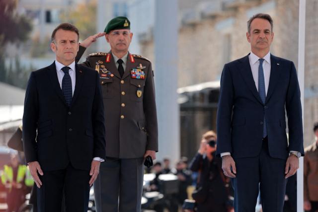 France's President Emmanuel Macron (L) and Greece's Prime Minister Kyriakos Mitsotakis arrive to visit Greece's new French-built frigate "Kimon" at the port of Pireus near Athens, on April 25, 2026. (Photo by Ludovic MARIN / AFP)
