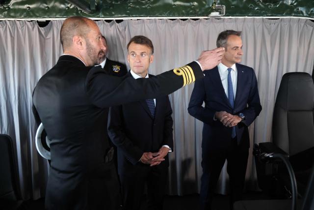 France's President Emmanuel Macron (C) and Greece's Prime Minister Kyriakos Mitsotakis (R) visit Greece's new French-built frigate "Kimon" at the port of Piraeus near Athens, on April 25, 2026. (Photo by Ludovic MARIN / AFP)