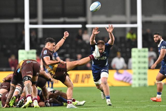 Reds' Kalani Thomas (C) kicks the ball during the Super Rugby Pacific match between the Blues and Queensland Reds at One New Zealand Stadium in Christchurch on April 25, 2026. (Photo by Sanka VIDANAGAMA / AFP)
