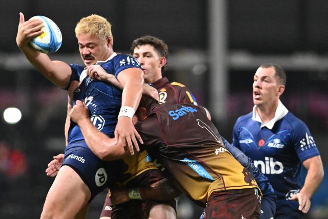 Blues' AJ Lam (L) is tackled by the Reds' defence during the Super Rugby Pacific match between the Blues and Queensland Reds at One New Zealand Stadium in Christchurch on April 25, 2026. (Photo by Sanka VIDANAGAMA / AFP)