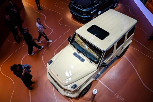 Visitors look at a Mercedes-Benz G500 at the Beijing Auto Show in Beijing on April 25, 2026. (Photo by Greg Baker / AFP)
