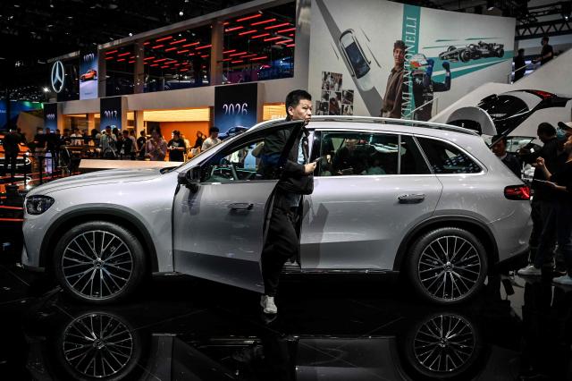 A man gets out of a Mercedes-Benz GLC SUV at the Beijing Auto Show in Beijing on April 25, 2026. (Photo by Greg Baker / AFP)