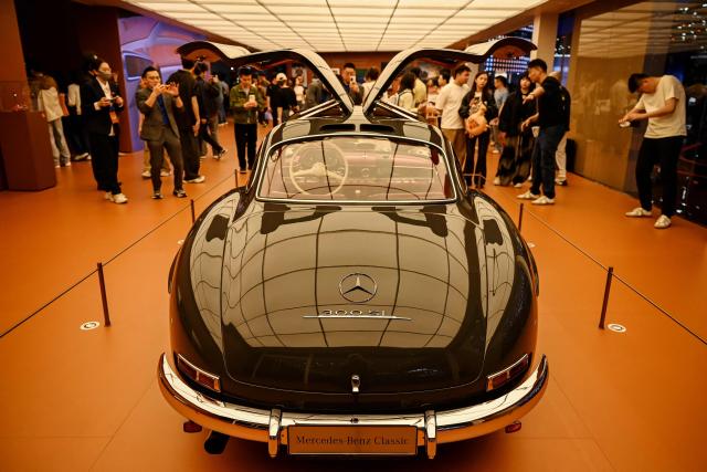 Visitors look at a 1954 Mercedes-Benz 300SL Coupe at the Beijing Auto Show in Beijing on April 25, 2026. (Photo by Greg Baker / AFP)