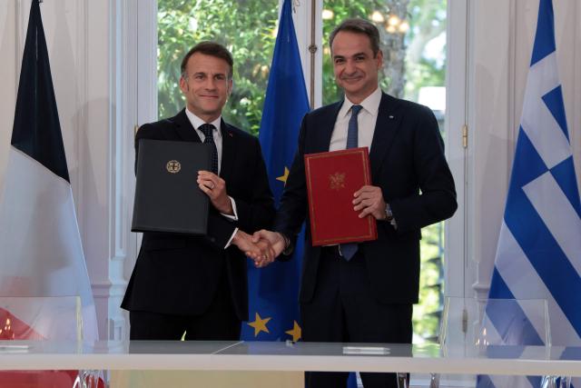 France's President Emmanuel Macron and Greece's Prime Minister Kyriakos Mitsotakis pose after signing bilateral agreements at Maximos mansion, in Athens, on April 25, 2026. The two leaders signed a text titled “Enhanced Comprehensive Strategic Partnership between Greece and France” and signed the renewal of the Strategic Relationship Agreement for cooperation in security and defense. (Photo by Ludovic MARIN / AFP)