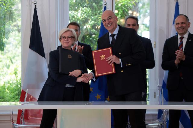 France's Defence Minister Catherine Vautrin shakes hands with Greece's Defence Minister Nikolaos Dendias after signing bilateral agreements at Maximos mansion, in Athens, on April 25, 2026. The two leaders signed a text titled “Enhanced Comprehensive Strategic Partnership between Greece and France” and signed the renewal of the Strategic Relationship Agreement for cooperation in security and defense. (Photo by Ludovic MARIN / AFP)