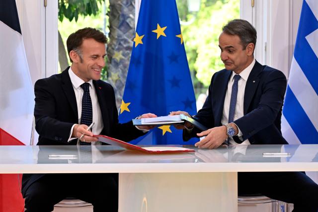 France's President Emmanuel Macron and Greece's Prime Minister Kyriakos Mitsotakis shake hands after signing bilateral agreements at Maximos mansion, in Athens, on April 25, 2026. The two leaders signed a text titled “Enhanced Comprehensive Strategic Partnership between Greece and France” and signed the renewal of the Strategic Relationship Agreement for cooperation in security and defense. (Photo by Aris MESSINIS / AFP)